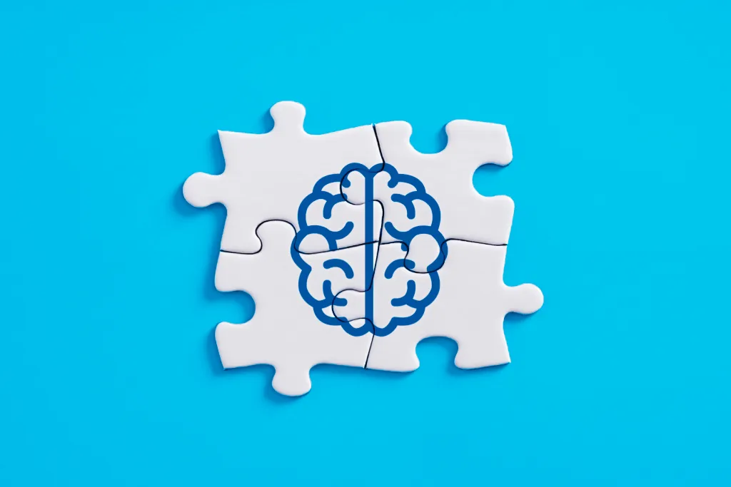 Drawing of a brain on puzzle pieces fitted together on a blue field
